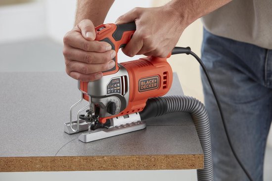 Oranje en zilveren Black+Decker decoupeerzaag met snelheidsinstelling, verbonden met stofafzuiging.