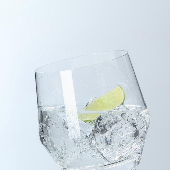 Een close-up van een glas water met ijs, bubbels en een limoenschijfje, met een kantelend effect.