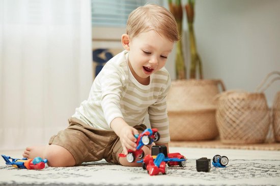 Jongen speelt met blauw en geel magnetisch speelgoed.