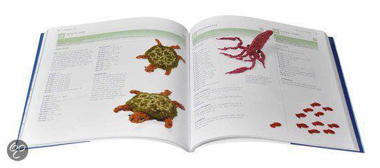 Twee gebreide schildpadden en een rode octopus op een open boek met vispatronen.