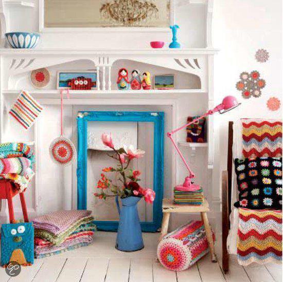 Gezellige kamer met open haard, gevuld met gehaakte plaids, kussens en accessoires.