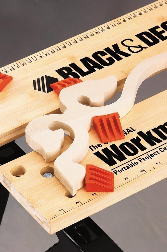 Close-up van een houten krul met oranje klemmen op de Black & Decker Workmate 536.