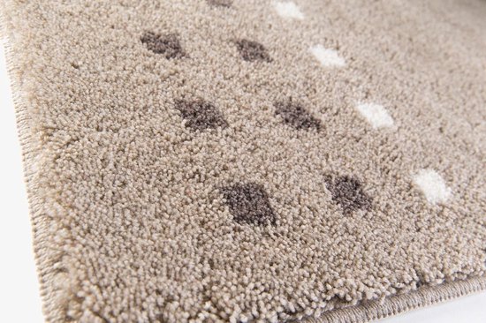 Close-up van een beige badmat met bruine en witte vierkantjes.
