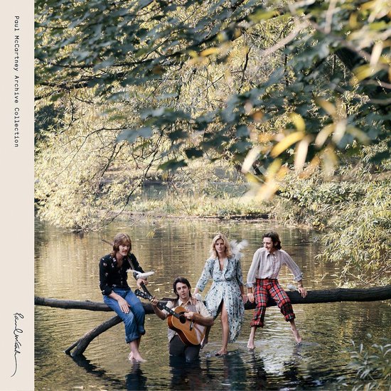 Paul McCartney en Wings zittend op een boomstam in het water, met de tekst 'Paul McCartney Archive Collection'.