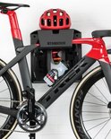 Zwarte en rode racefiets met rode helm en bidon op een Stasdock muurbeugel.