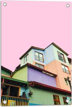 WallClassics - Tuinposter – Gekleurde Huizen met Roze achtergrond - 40x60 cm Foto op Tuinposter (wanddecoratie voor buiten en binnen)