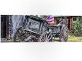 WallClassics - PVC Schuimplaat - Oude Houten Boerenkar met Amerikaanse Vlag - 90x30 cm Foto op PVC Schuimplaat (Met Ophangsysteem)