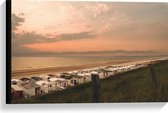 Canvas - Rijen Kleine Witte Strandhuisjes op Strand in Nederland bij de Ondergaande Zon - 60x40 cm Foto op Canvas Schilderij (Wanddecoratie op Canvas)