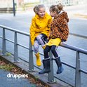 Twee lachende meisjes, een met gele regenjas, luipaardprint leggings en gele laarzen. De ander met luipaardprint jas, gele rok en zwarte laarzen.