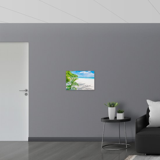 PVC Schuimplaat- Palmbladeren Hangend boven Wit Strand bij Helderblauwe Zee - 60x40 cm Foto op PVC Schuimplaat