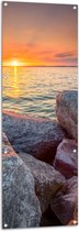 WallClassics - Tuinposter – Zon achter Water met Stenen - 50x150 cm Foto op Tuinposter  (wanddecoratie voor buiten en binnen)