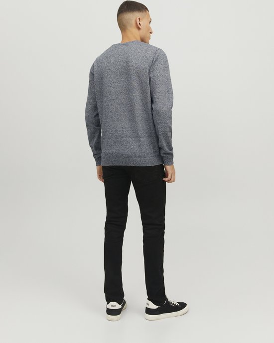 Man, achterkant, draagt een donkergrijs gebreide trui met ronde hals en zwarte jeans.