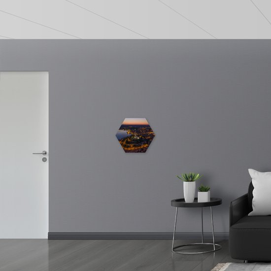 PVC Schuimplaat Hexagon - Kerkje in Midden van Verlicht Stadje - 50x43.5 cm Foto op Hexagon (Met Ophangsysteem)