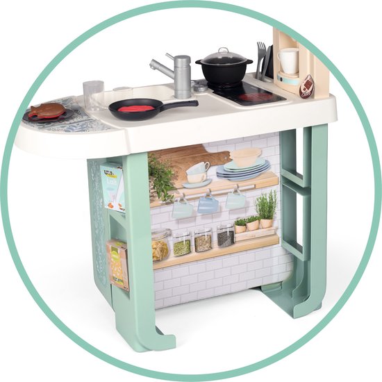 Achterkant van een mintgroene speelkeuken met planken, servies, kruidenpotjes en een aanrecht.