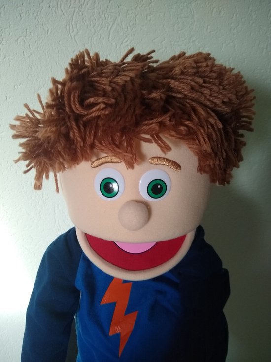 Handpop Tommie met warrig bruin haar, groene ogen en een blauw shirt met oranje bliksemprint.