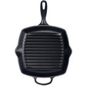Zwarte vierkante gietijzeren grillpan met ribbels en een handvat, gefotografeerd op een witte achtergrond.