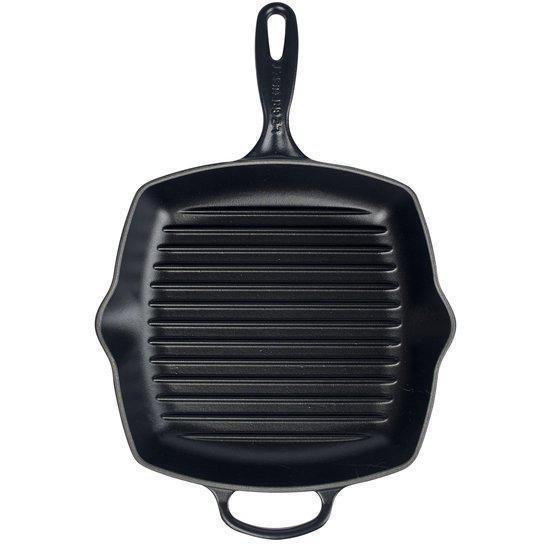 Zwarte vierkante gietijzeren grillpan met ribbels en een handvat, gefotografeerd op een witte achtergrond.