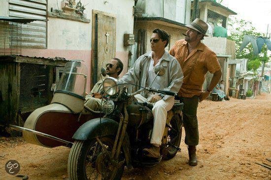 Johnny Depp op een motor met zijspan, naast hem Aaron Eckhart. Een man in een bruin shirt leunt op de motor.