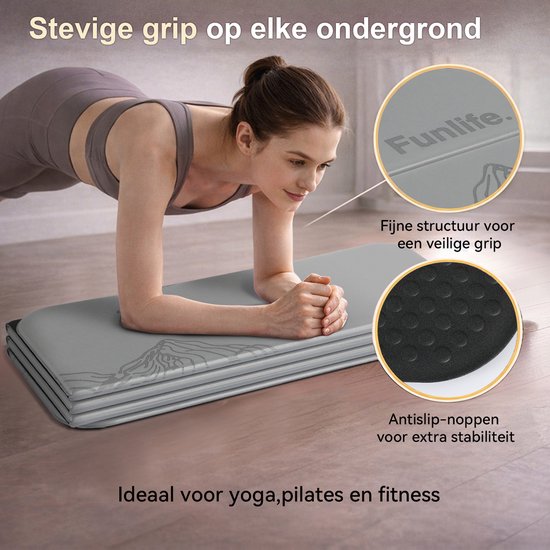 Grijze trainingsmat met bergmotief, met detail van de antislipstructuur. Vrouw doet een plankoefening.