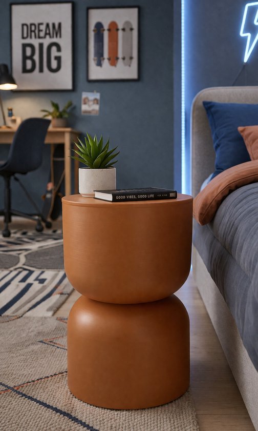 Bruine bijzettafel van metaal in organische zandlopervorm, staand naast een bed in een slaapkamer.