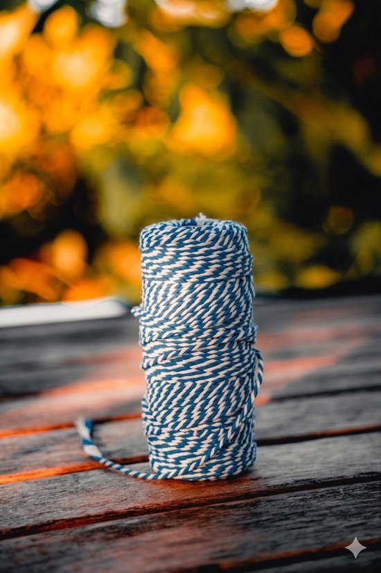 Rol blauw-wit gevlochten touw op een houten tafel, achtergrond vervaagd.