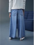Kind draagt wijde, ronde jeans in lichtblauw denim, van achteren gezien.