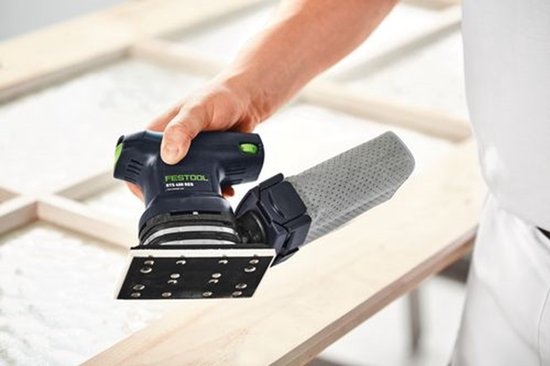Hand houdt de Festool RTS 400 REQ schuurmachine met grijze stofzak vast.