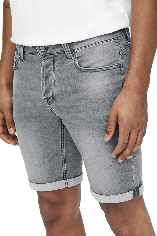 Detail van een grijze denim short met omgeslagen broekspijpen en zakken.