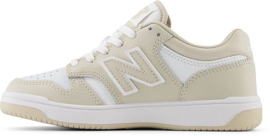 Zij-aanzicht van een beige en witte New Balance sneaker met een witte zool.