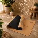 Een deels opgerolde yogamat van kurk met een mandala patroon op een lichte ondergrond.