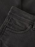 Close-up van de tailleband en zak van een donkergrijze jeans.