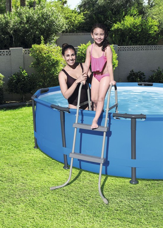 Vrouw en meisje in badkleding bij een ronde blauwe zwembad met een grijze ladder.
