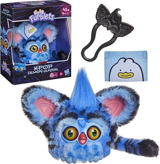 Doos met een blauwe Furby Furblet, losse Furblet met zwart haaraccessoire en label, en een ander label met eend.