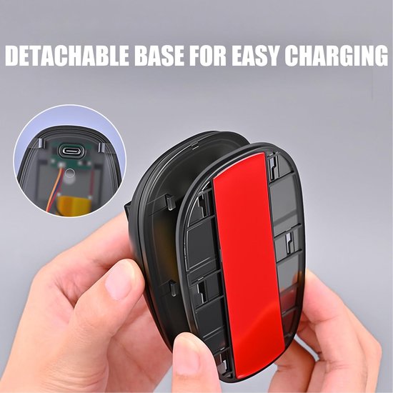 Handen tonen een zwarte, ovale oplaadbare basis met rode tape en een USB-C poort in een cirkelvormige inlay.