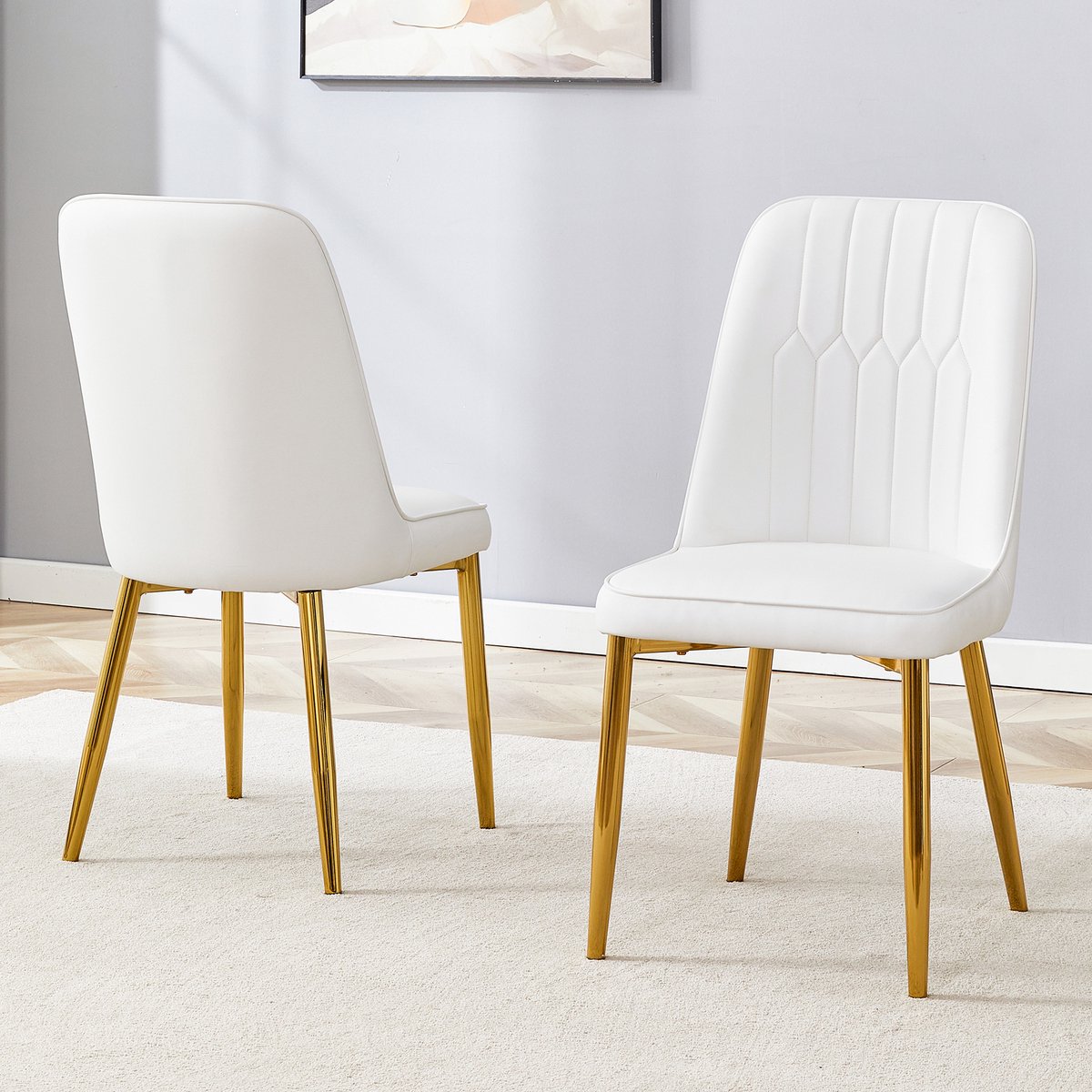 Twee witte eetkamerstoelen van kunstleer: modern en minimalistisch design, voorzien van een verbrede zitting en rugleuning en antislip metalen poten, geschikt voor eetkamers en keukens.