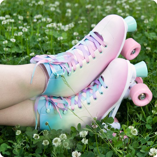 Roller skates met paarse, roze en blauwe veters en pastelkleurige gradiënt, gedragen in het gras.