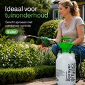 Vrouw met groene handschoenen gebruikt een witte 5 liter drukspuit met groene details in een tuin.