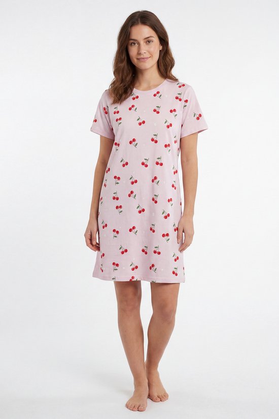 Model staat in roze nachthemd met korte mouwen en kersenprint.