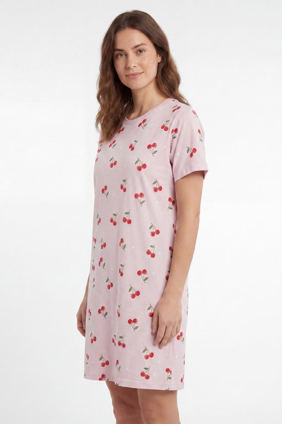 Model in roze nachthemd met korte mouwen, bedrukt met kersen en sterretjes.