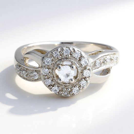 Zilveren ring met een centrale witte diamant, omringd door witte topaasjes op een dubbele band.