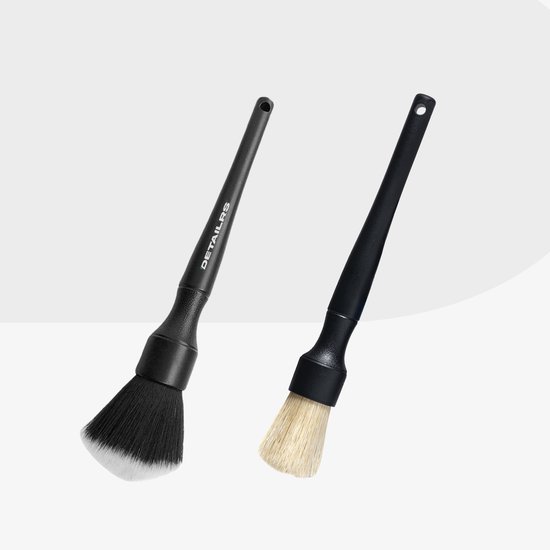 Twee detailkwasten met zwarte handgrepen: één met zwarte en witte haren, één met lichte haren.