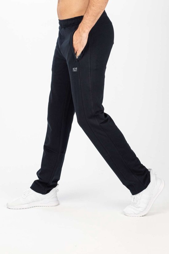Man in beweging, draagt een zwarte joggingbroek met ritszak, witte sneakers en 'SJS' logo.