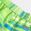 Groene zwembroek met blauwe en witte strepen. Detail van de elastische tailleband.