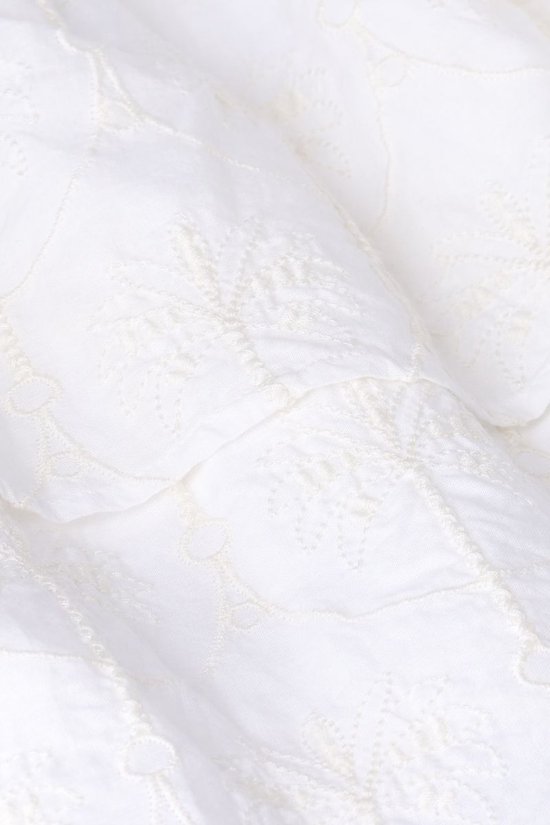 Detail van witte stof met subtiele bloemenbroderie.