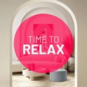 Grijze poef in een stijlvolle woonkamer met roze bank en tekst "TIME TO RELAX".