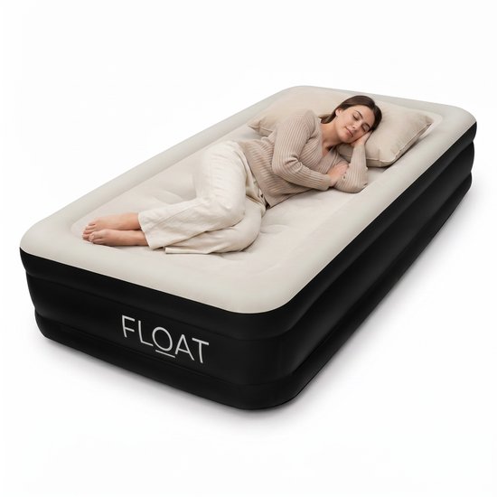 Een vrouw slaapt op een crème-kleurig luchtbed met zwarte zijkanten. Het "FLOAT" logo staat op de zijkant.