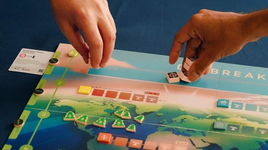 Bordspel met wereldkaart, groene bomen en tegels. "DAYBREAK" tekst zichtbaar.