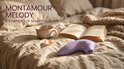 Lila Montamour Melody vibrator op een bed met een boek en een kop koffie.