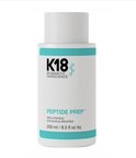 Witte K18 Peptide Prep Detox Shampoo fles met turquoise banden en zwarte tekst.