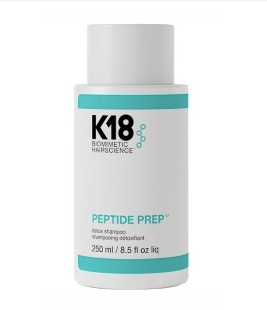 Witte K18 Peptide Prep Detox Shampoo fles met turquoise banden en zwarte tekst.